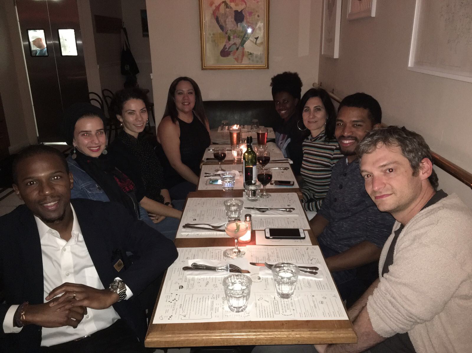 Eight people seated at a table at a restaurant for dinner